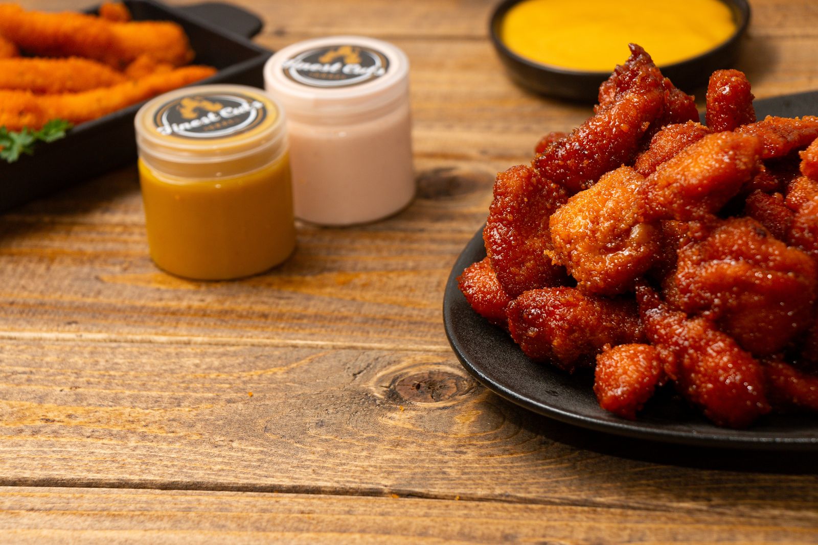 Finest Cuts signature sauce jars beside crispy chicken
